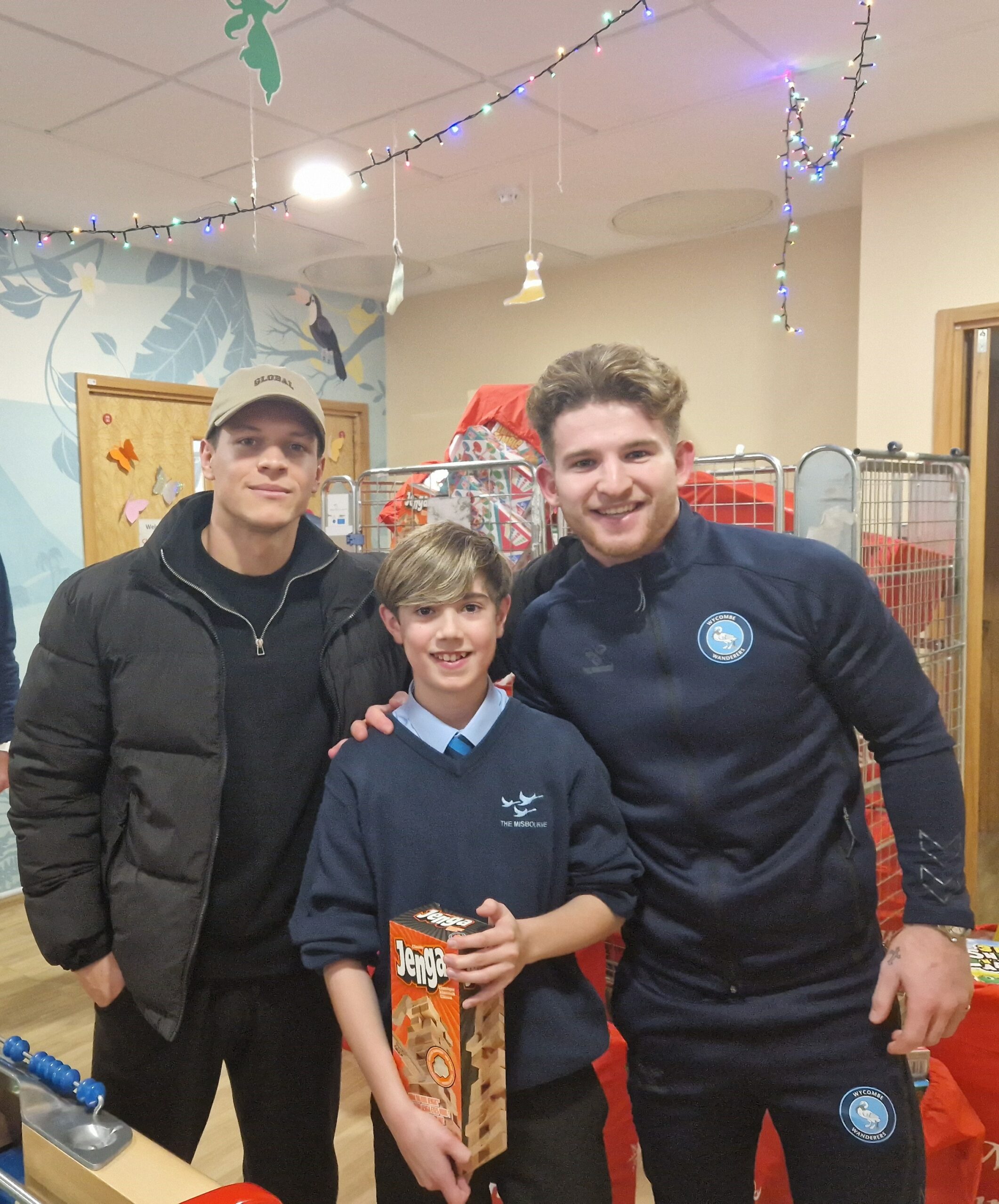 Tjay De Barr and Jasper Pattenden with a child during their visit to Wycombe Hospital