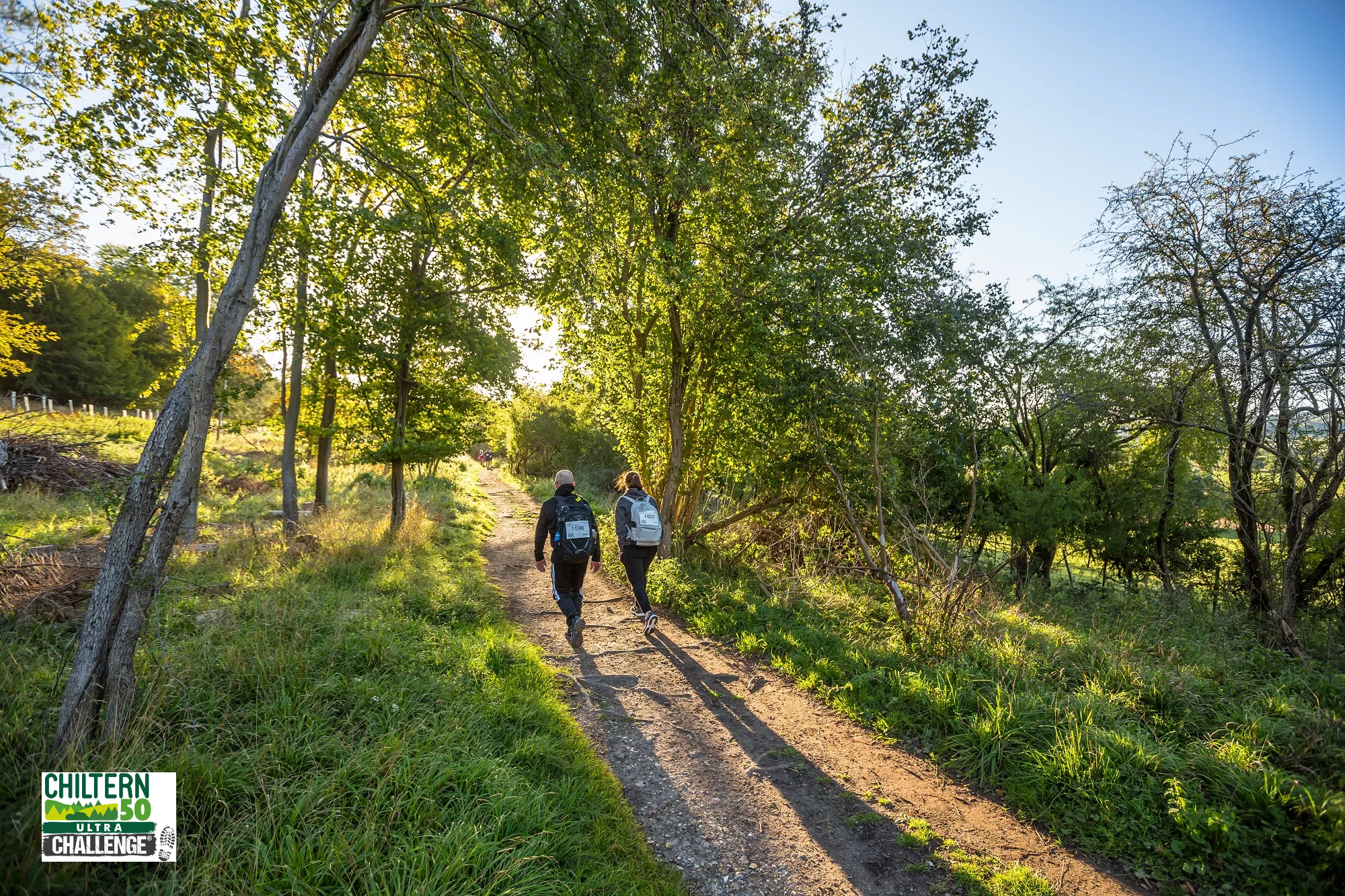Two people walking through woodland in the Chiltern Hills